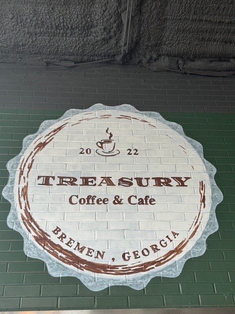 White and Burgundy sign for Treasury Coffee & Cafe housed in the old bank building a block from downtown Bremen